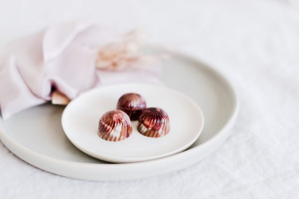 Praline aus Milchkuvertüre gefüllt mit Gelee schwarze Johannisbeere und Süssholz Karamell Ganache