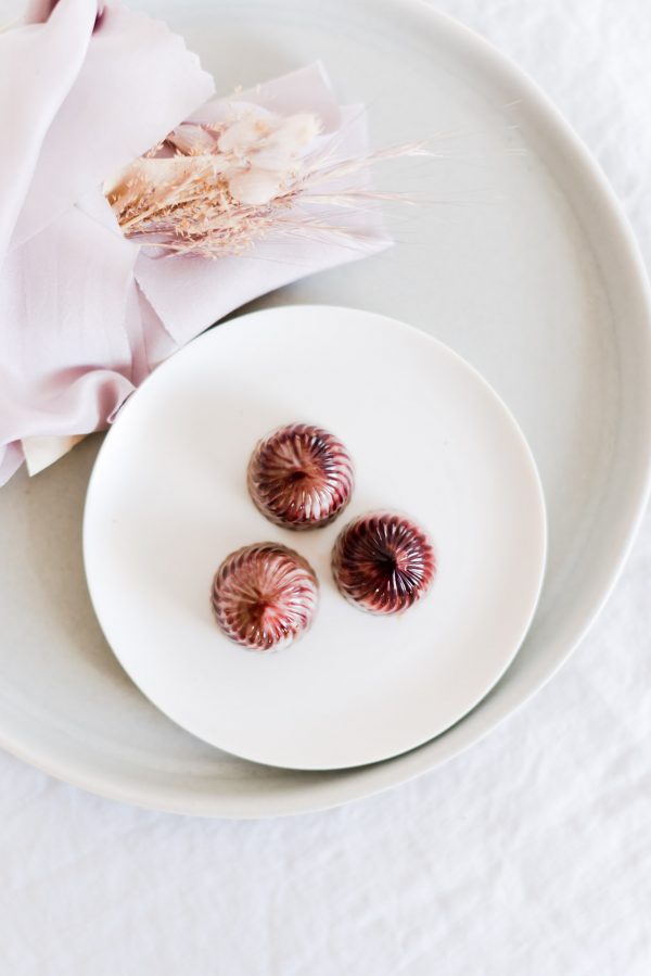 Praline aus Milchkuvertüre gefüllt mit Cassis Gelee und Lakritz Karamell Ganache